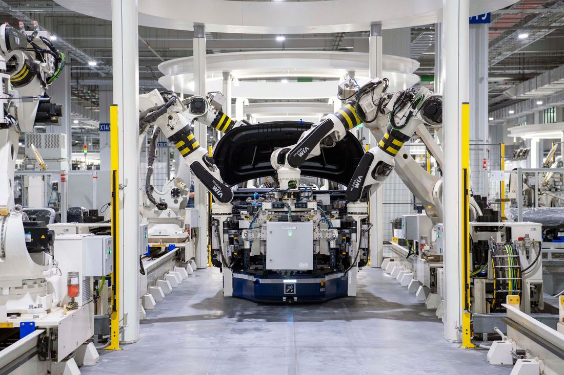 Robotic arms assembling a vehicle on an automotive production line.