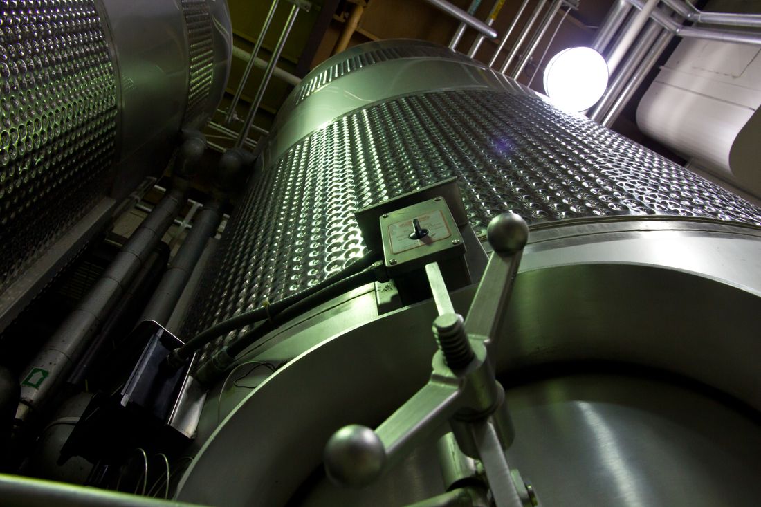 Stainless steel processing tanks and connected pipework.